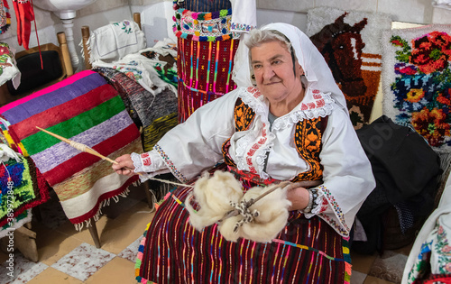 An old woman weaver spun wool on her hand photo