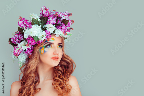 Daydreaming young lady woman with floral headband from lilac flowers