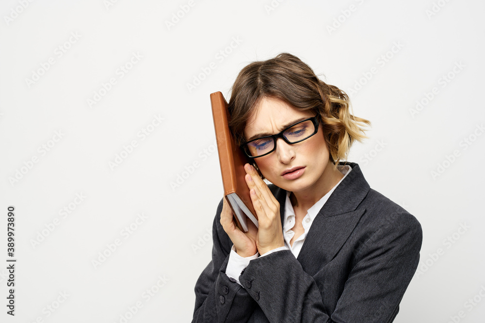 Business woman with notepad and glasses work light background cropped view of suit model. Business woman with notepad and glasses work light background cropped view of suit model.