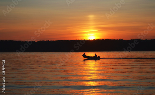 Sunset on the lake. A lone boat. © Эдуард Андреев