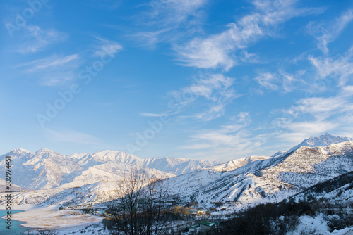 Beautiful snow-capped mountain peaks of the Tien Shan against the blue sky in winter