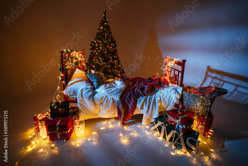 New Year 2021 interior with candles  bulbs and bokeh. Room decorated to christmas celebration. Christmas tree with presents