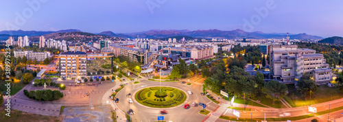 Podgorica Montenegro in the evening. Night cityscape of the capital of a small country in the Balkans, south east Europe. Traffic on roundabout in residential and commercial city center. Aerial view.