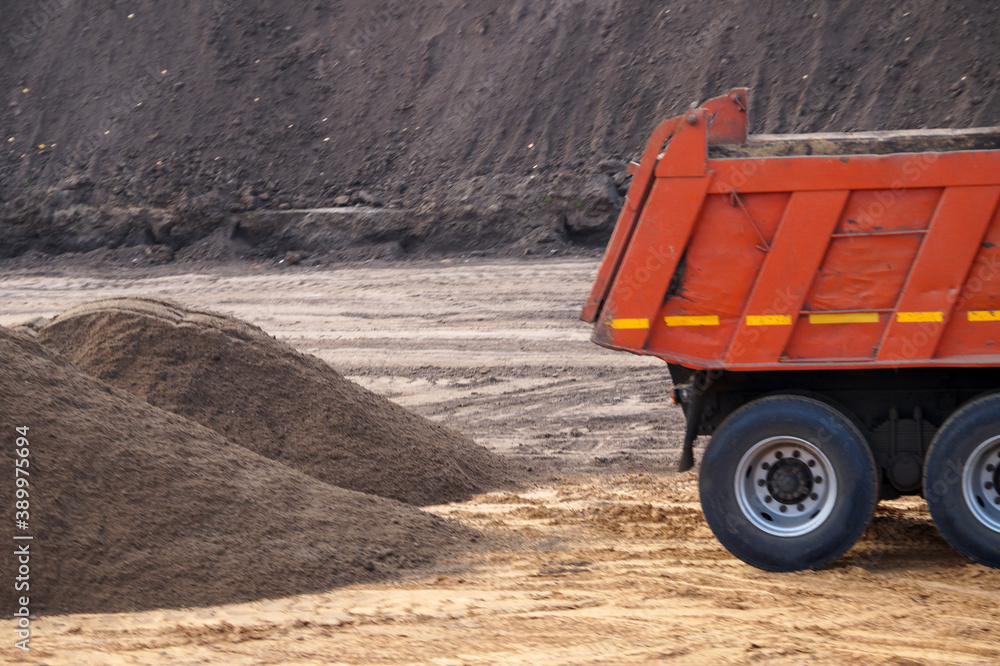 Obraz premium dump truck and a pile of sand at a construction site close up