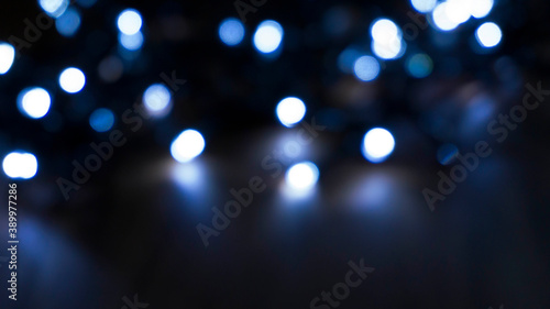 Light effect on a dark background, bright lights, blur, bokeh. Reflection of neon light in water.