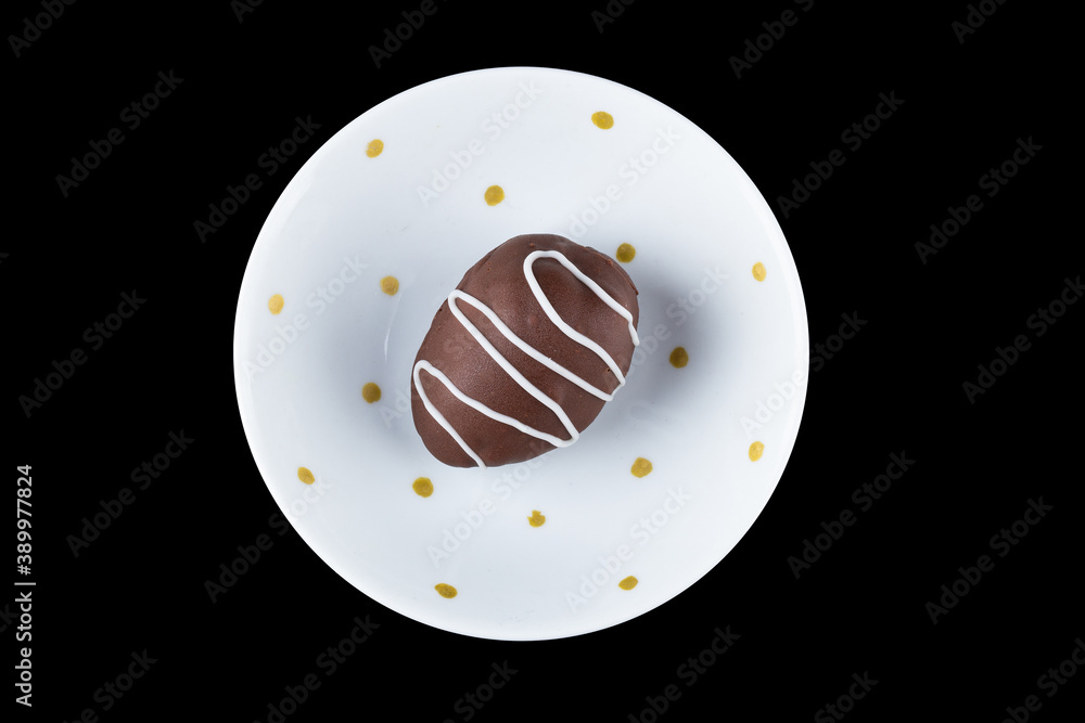 Fototapeta premium Chocolate truffle with strawberry filling isolated on black background. Closeup photography.