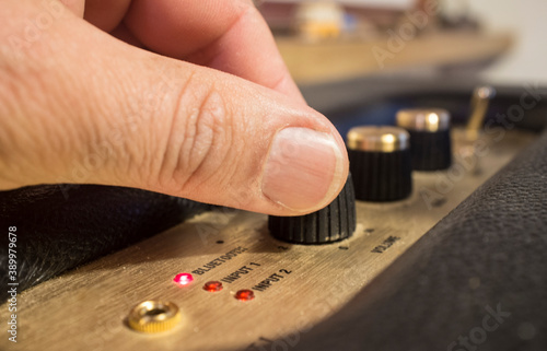 Fingers adjusts fine-tune controls of retro style bluetooth speaker