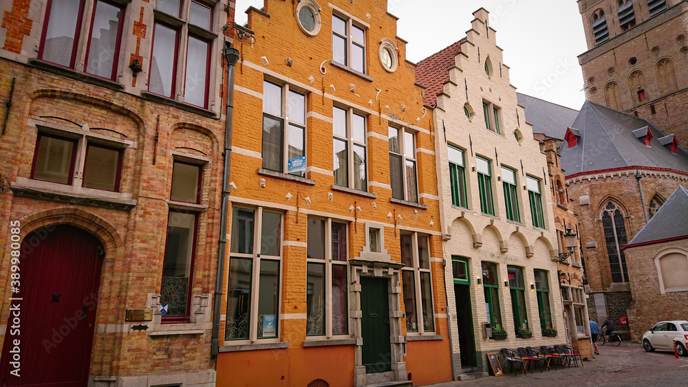 Fototapeta premium Bruges, Belgium - May 12, 2018: Roofs And Windows Of Old Authentic Brick Houses On Street Sint-Jakobsstraat