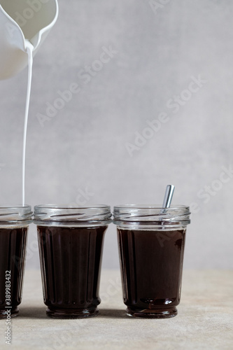 Coffee with vegetable milk, cocount milk is poured into a glass
