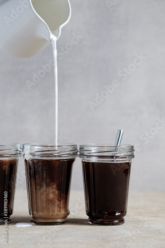 Coffee with vegetable milk, cocount milk is poured into a glass