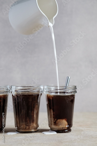 Coffee with vegetable milk, cocount milk is poured into a glass