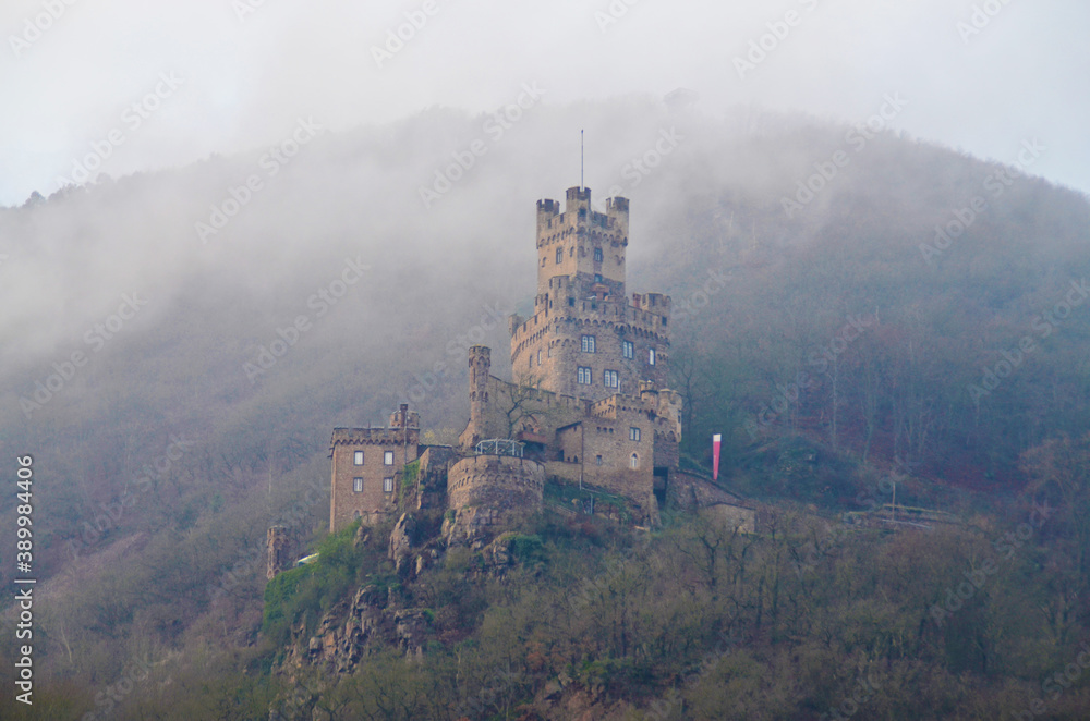 Castle in fog on a mountainside
