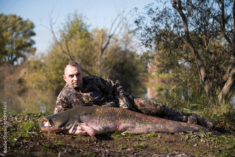 Naklejka premium Fisherman with catfish