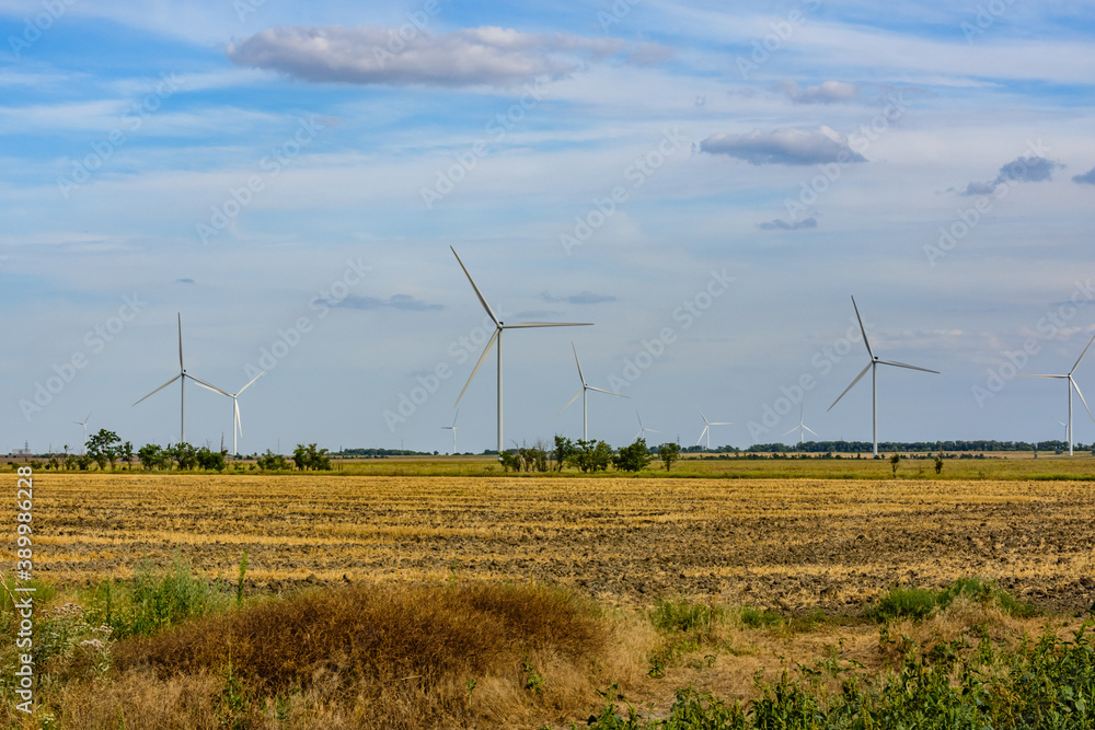 Wind turbines at the agricultural field. Clean energy. Ecological concept Wind turbines at the agricultural field. Clean energy. Ecological concept