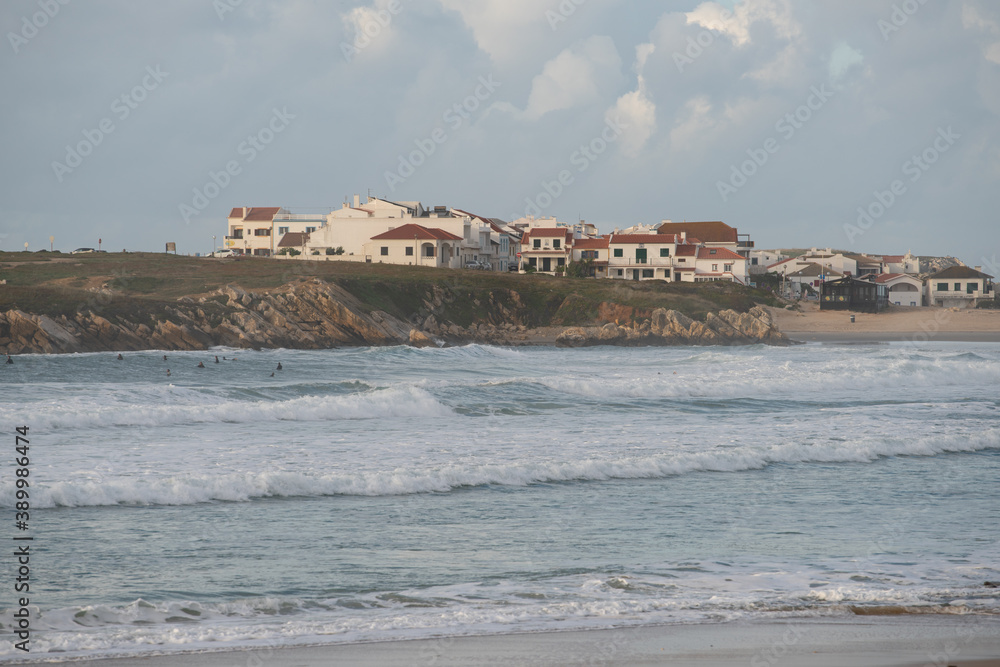 Baleal Island beach and beautiful houses with surfers on the atlantic ocean in Peniche, Portugal