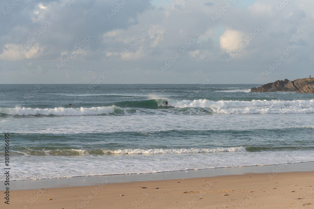 Surfers surfing in Baleal Island beach atlantic ocean waves in Peniche, Portugal