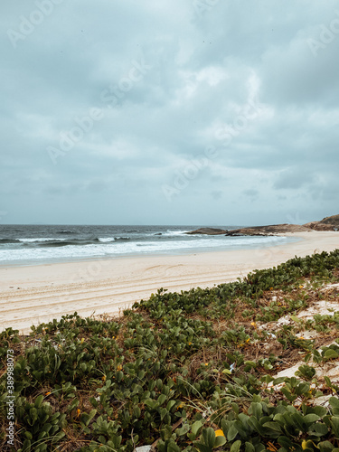 Vertical shot of a beach surrounded by the sea under a cloudy sky in Rio de Janeiro, Brazil photo