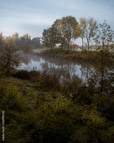 River during sunrise with fields and trees