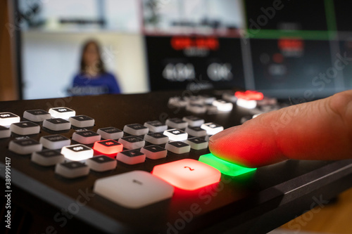 Professional equipment for live video streaming, man pushes button, monitor with split screen
