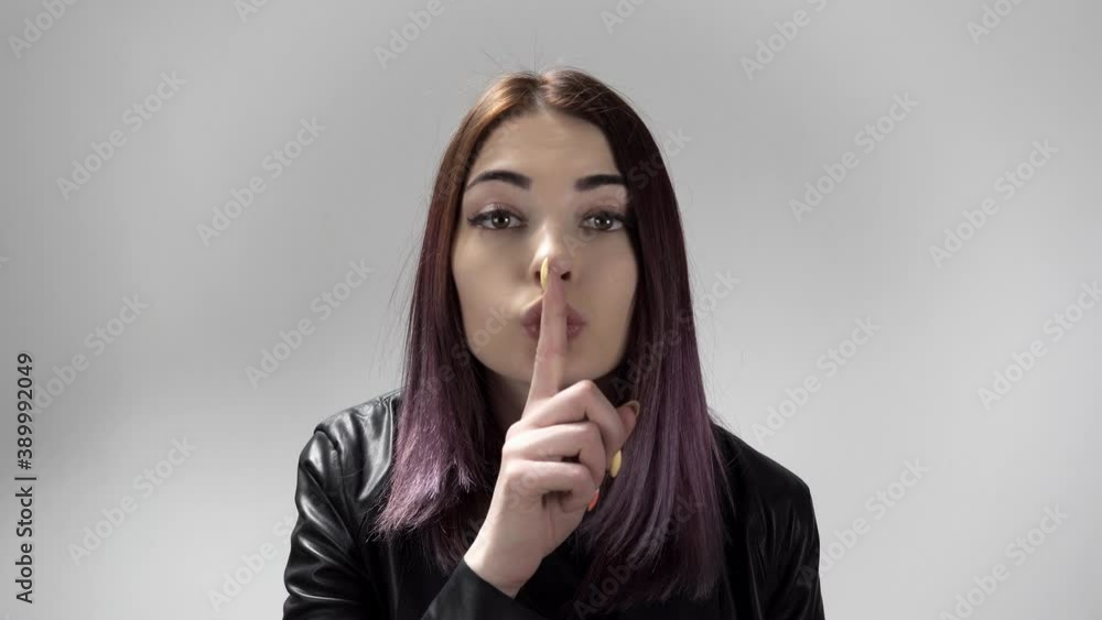 Portrait of young caucasian woman keeping a secret or asking for silence on the white background. Pretty lady brings forefinger to her lips. She makes shush movement. Theme of gesturing and signs. Portrait of young caucasian woman keeping a secret or asking for silence on the white background. Pretty lady brings forefinger to her lips. She makes shush movement. Theme of gesturing and signs.