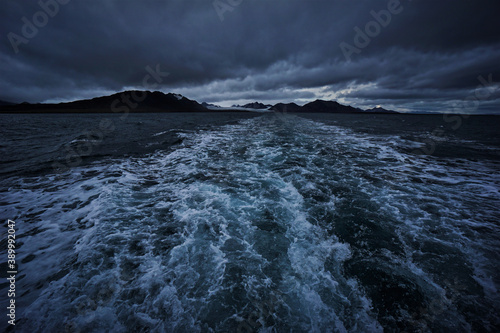 Wide-angle shot of the barents sea and the mountains and glaciers in the Isfjorden National Park, Spitsbergen, Norway on a dark and stormy day