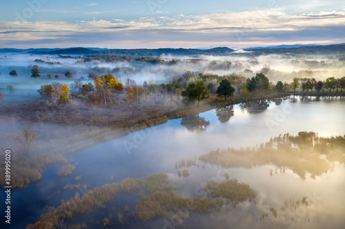 Beautiful aerial view of morning fog and sunrise in autumn forest.