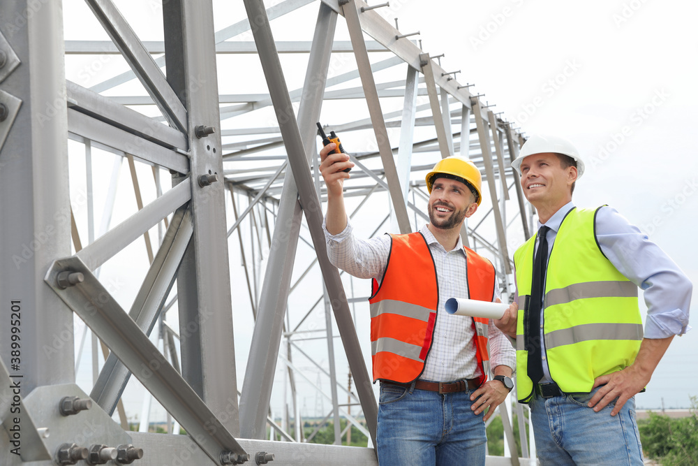 Professional engineers working on installation of electrical substation outdoors Professional engineers working on installation of electrical substation outdoors