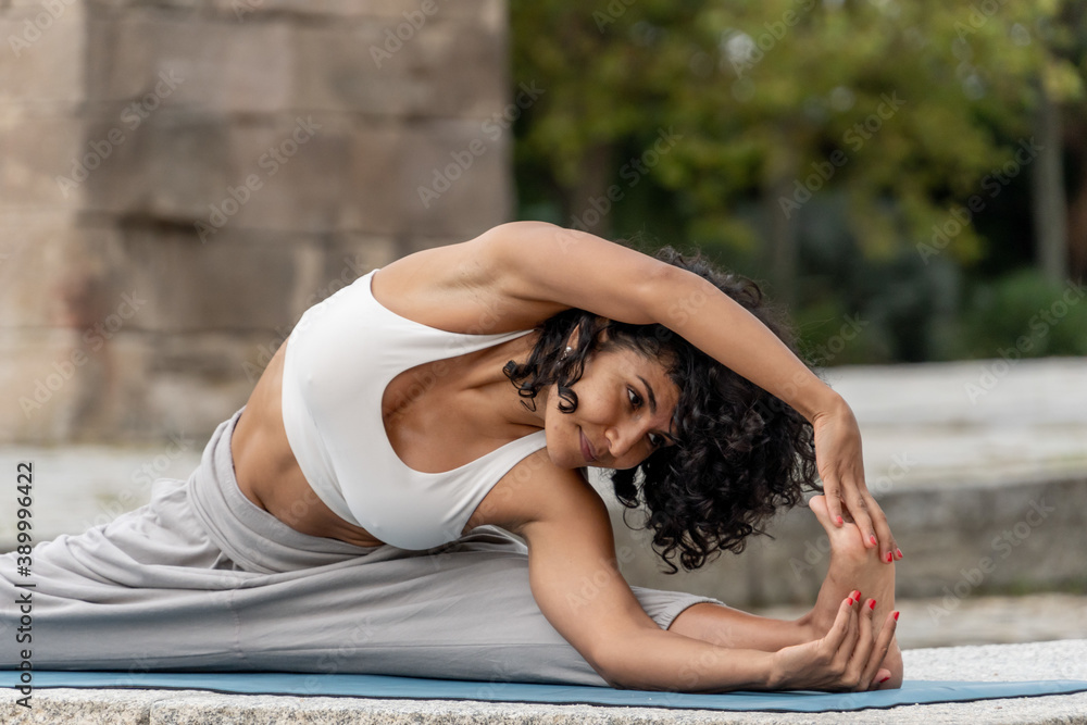 Closeup shot of a Spanish woman practices yoga outdoor - obrazy, fototapety, plakaty 