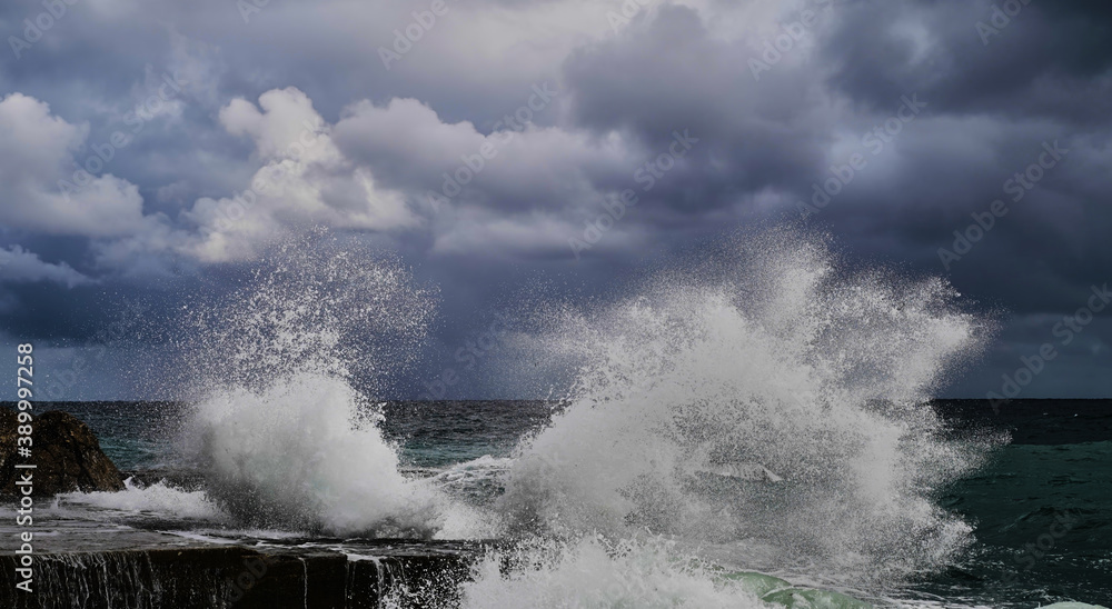 Stormy weather at sea. Strong waves hitting stones. Strong explosions from the waves of the sea.