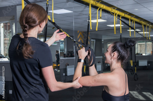 Women work out in the gym with equipment loop straps