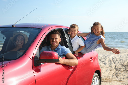Happy family in car near sea. Summer trip
