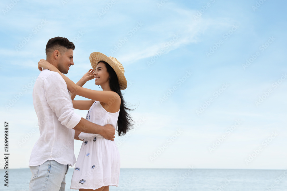 Lovely couple spending time together on beach near sea. Space for text Lovely couple spending time together on beach near sea. Space for text