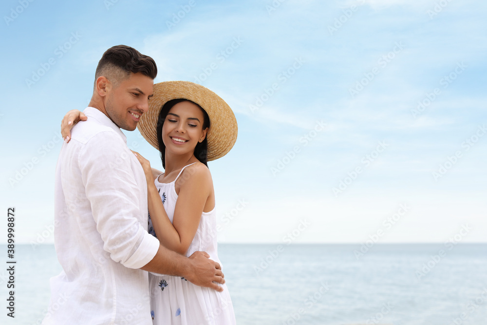 Lovely couple spending time together on beach near sea. Space for text Lovely couple spending time together on beach near sea. Space for text