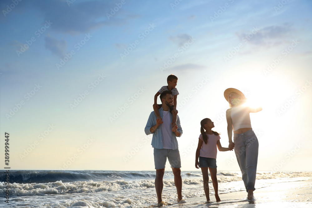 Happy family walking on sandy beach near sea Happy family walking on sandy beach near sea