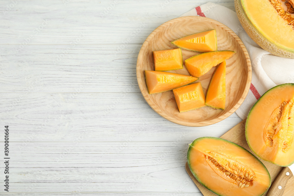 Tasty fresh cut melons on white wooden table, flat lay. Space for text Tasty fresh cut melons on white wooden table, flat lay. Space for text