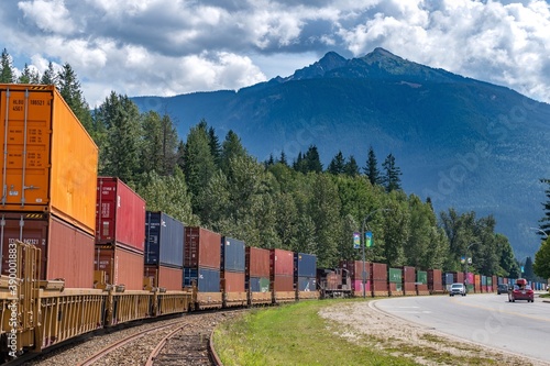 Bild auf Leinwand Cargo train on track through a mountain town