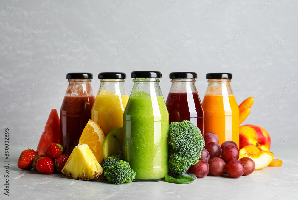 Bottles of delicious juices and fresh fruits on marble table Bottles of delicious juices and fresh fruits on marble table