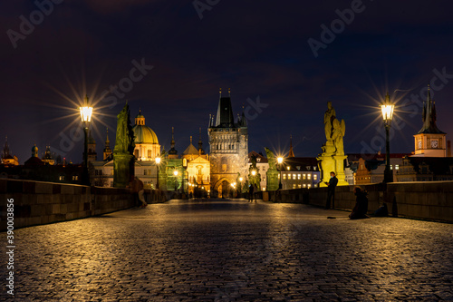  old paved sidewalk with paving stones in memory of Charles Bridge from the 14th century in the center of Prague and in the background the old bridge tower at night in the Czech Republic