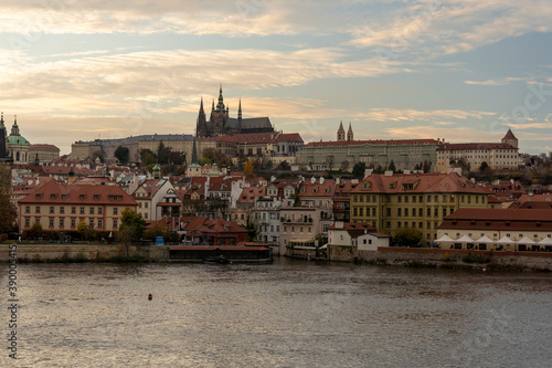 view of prague castle and st. vitus cathedral and stone charles bridge from 14 century on flowing river vltave at sunset in the center of prague sky is colored by the sun