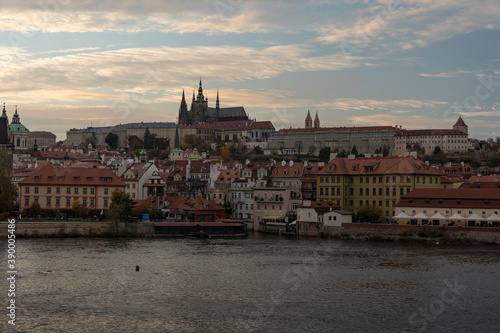 view of prague castle and st. vitus cathedral and stone charles bridge from 14 century on flowing river vltave at sunset in the center of prague sky is colored by the sun