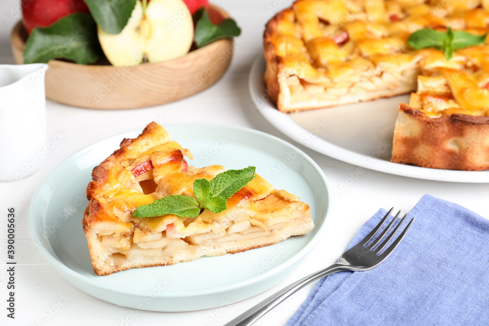 Slice of traditional apple pie with mint on white wooden table Slice of traditional apple pie with mint on white wooden table