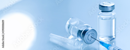 Photos Medical syringe with a needle and a bollte with vaccine.