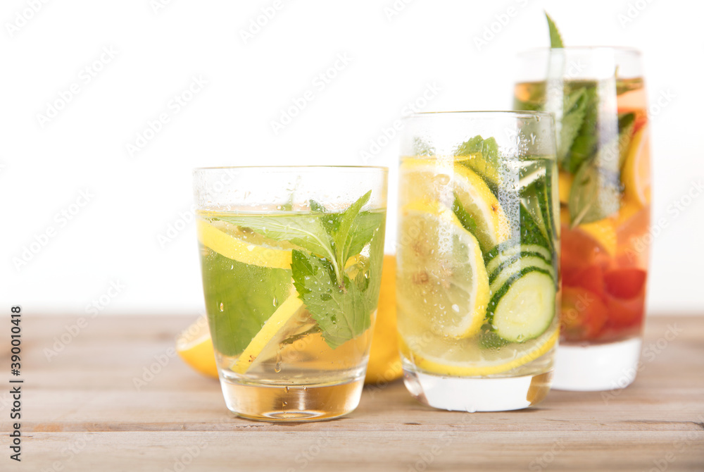 Fototapeta premium Three glasses of lemon cucumber mint water and freshly cut lemon fruit