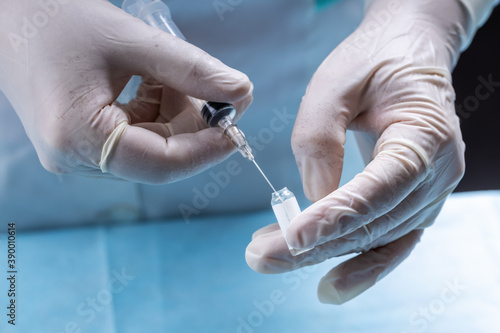 female doctor holding syringe and prepare for making vaccine or drug injection. medicare and vaccination concept. close up. selective focus. medic wearing white smock and surgical gloves