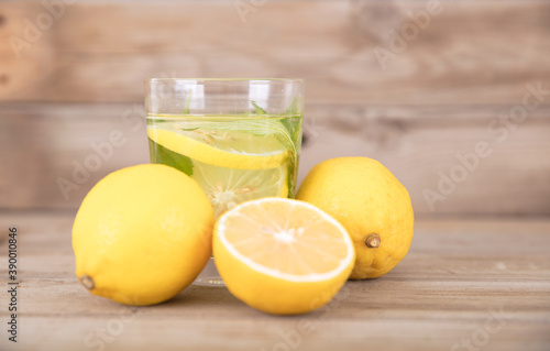A cup of brewed lemon tea and fresh lemon fruit