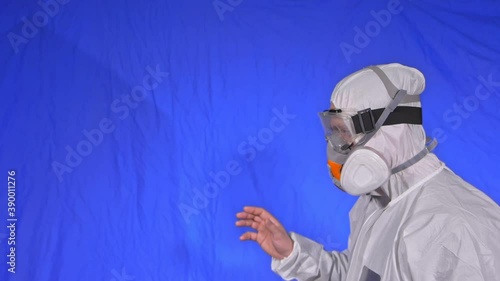 Scientist virologist in respirator. Slow motion. Man close up look, wearing protective medical mask. Concept health safety N1H1 virus protection coronavirus epidemic 2019 nCoV. Chroma key blue film. photo