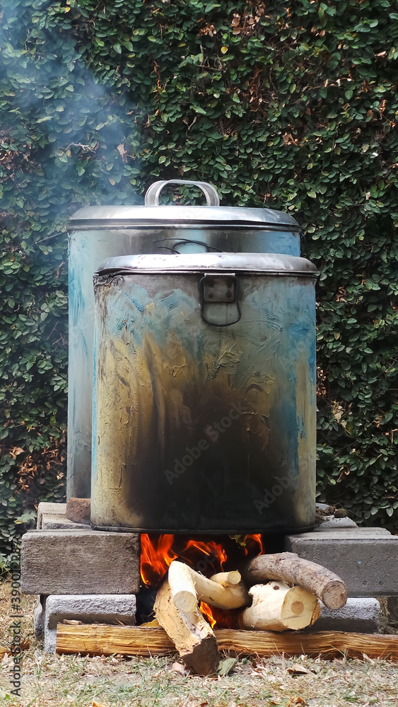 Fototapeta premium Traditional cooking. Cook water in a large pot using firewood