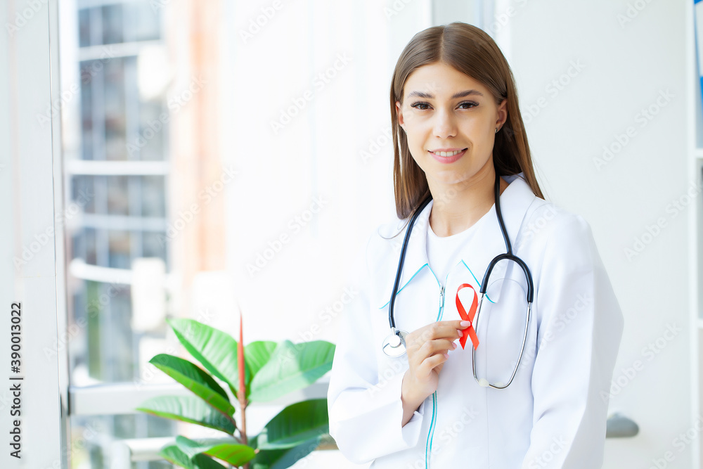 Doctor holding a red ribbon as a symbol of AIDS.