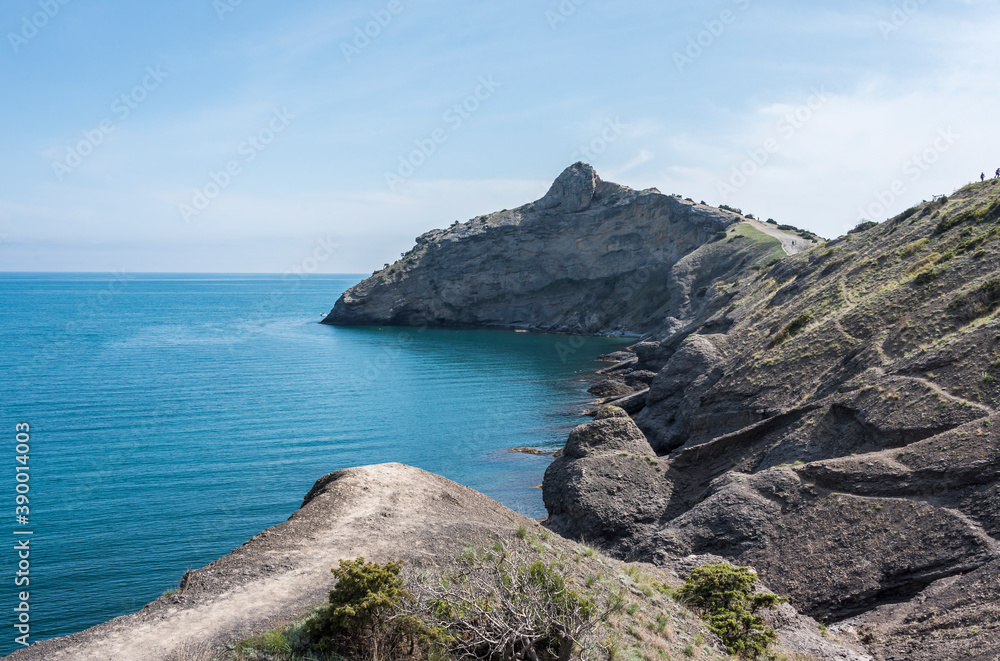 View of the mountains on the Black Sea coast with paths and small silhouettes of people on the horizon