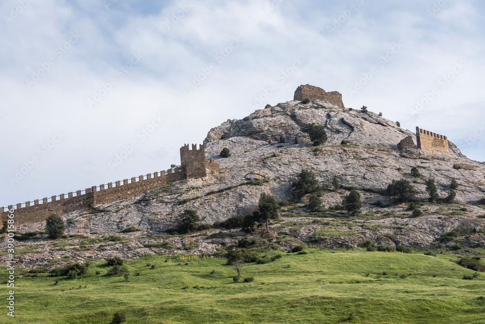 The wall that runs along the ridge of the mountain and the towers of Genoese fortress of the 14th century in the Sudak bay on the Peninsula of Crimea